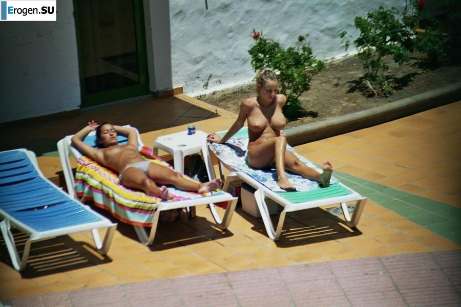 Girls sunbathe topless near the pool. Photo 39