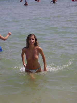 Sexy girl posing on the beach in shorts without a bra. Thumb 11